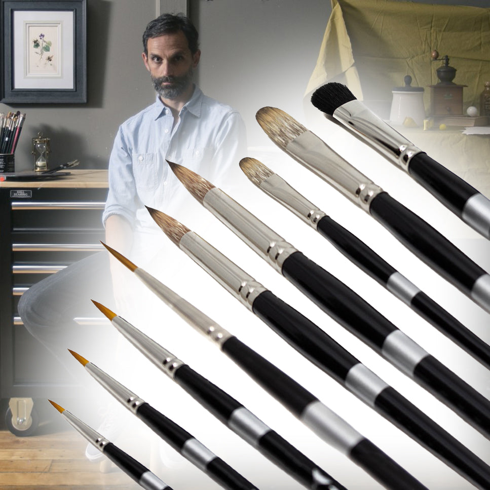 a man in a blue shirt behind a row of paintbrushes