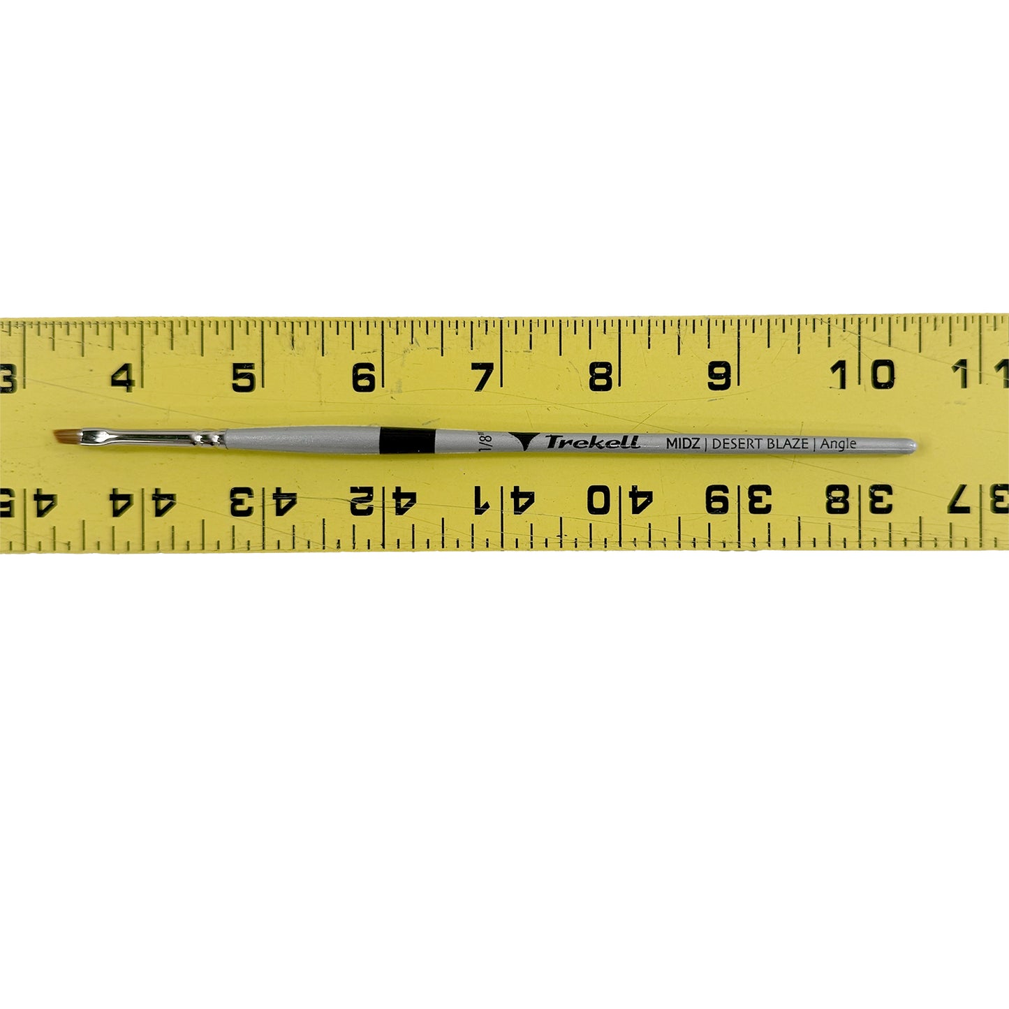 a yellow ruler with a Trekell paintbrush on top of it